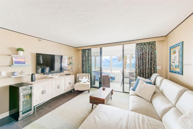 living room featuring a textured ceiling, wine cooler, and a wall of windows