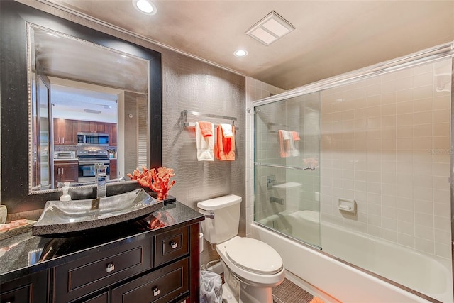 full bath with recessed lighting, combined bath / shower with glass door, vanity, and toilet