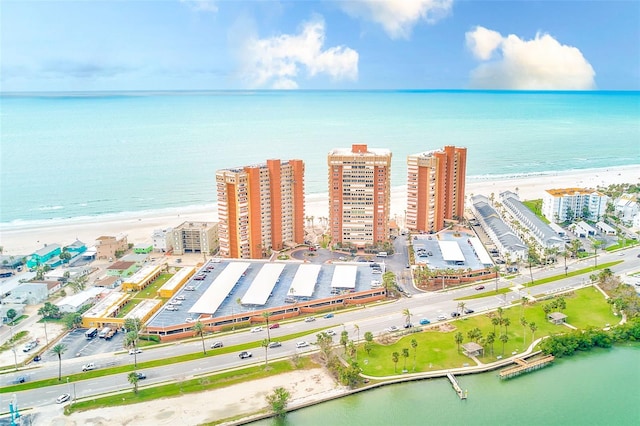 drone / aerial view featuring a water view, a city view, and a view of the beach