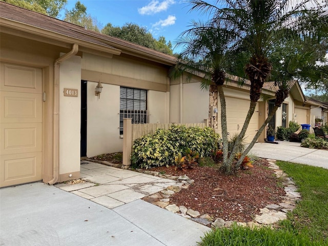 exterior space with driveway, an attached garage, and stucco siding