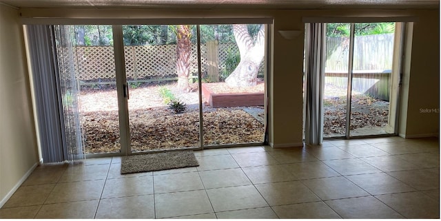 entryway featuring baseboards and tile patterned floors