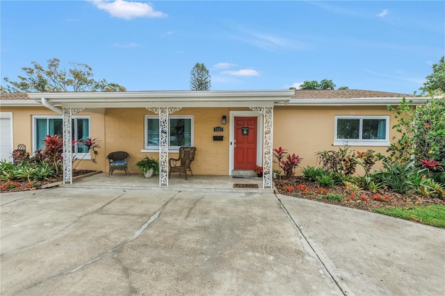 ranch-style home with stucco siding and a porch