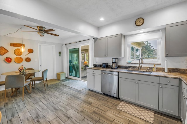 kitchen featuring a ceiling fan, a sink, gray cabinetry, dishwasher, and a wealth of natural light