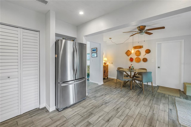 kitchen featuring visible vents, baseboards, ceiling fan, wood tiled floor, and freestanding refrigerator