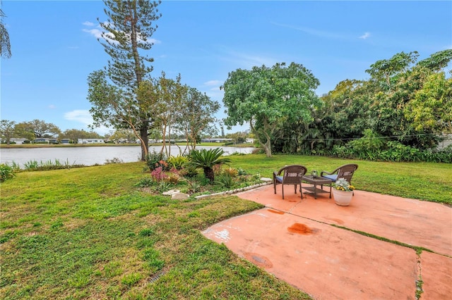 view of yard with a water view and a patio