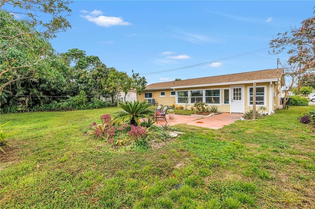 rear view of property with a patio area, a lawn, and stucco siding