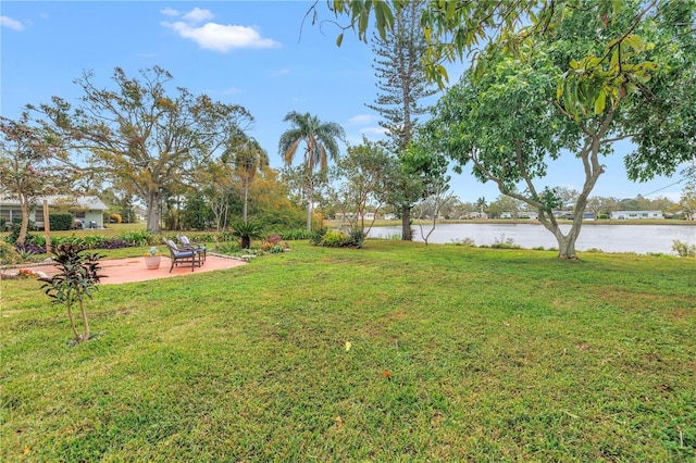 view of yard with a water view and a patio area