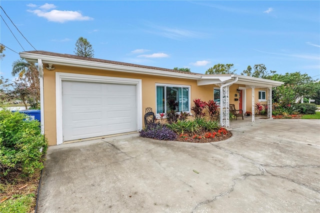 ranch-style home with stucco siding, an attached garage, and concrete driveway