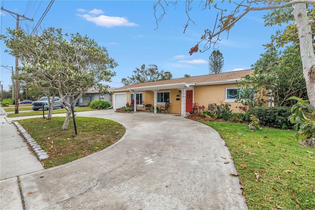 ranch-style home with concrete driveway, an attached garage, a front yard, and stucco siding