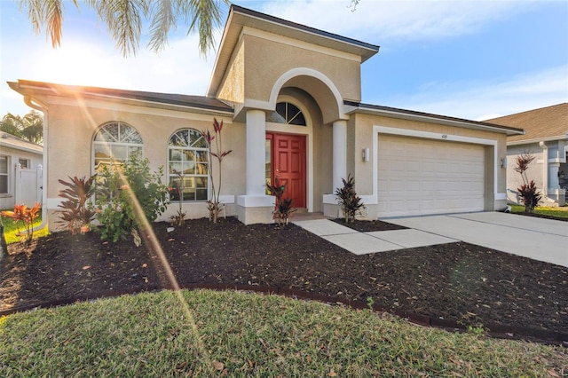 view of front of house featuring an attached garage, driveway, and stucco siding