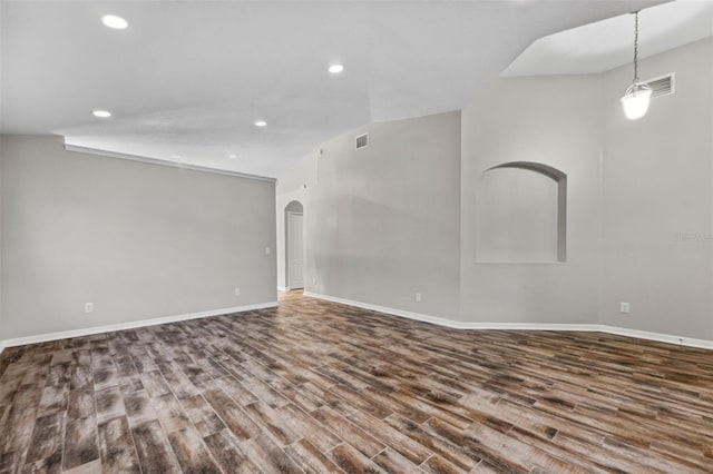 spare room with baseboards, visible vents, arched walkways, wood finished floors, and recessed lighting