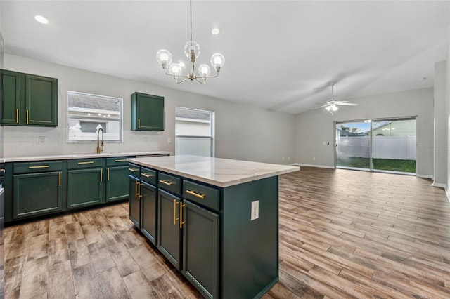 kitchen with a healthy amount of sunlight, light wood finished floors, light countertops, and green cabinetry