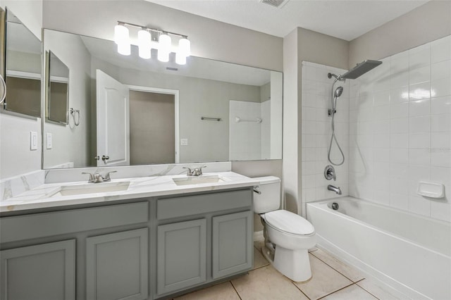 bathroom featuring toilet, tile patterned flooring,  shower combination, and a sink