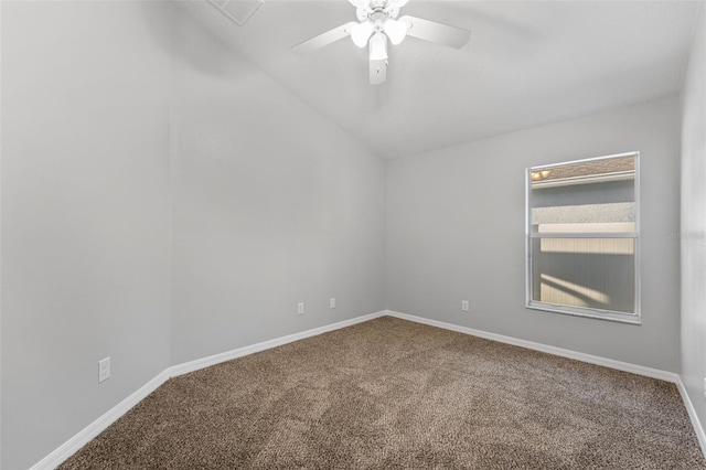 carpeted spare room featuring baseboards, vaulted ceiling, and a ceiling fan