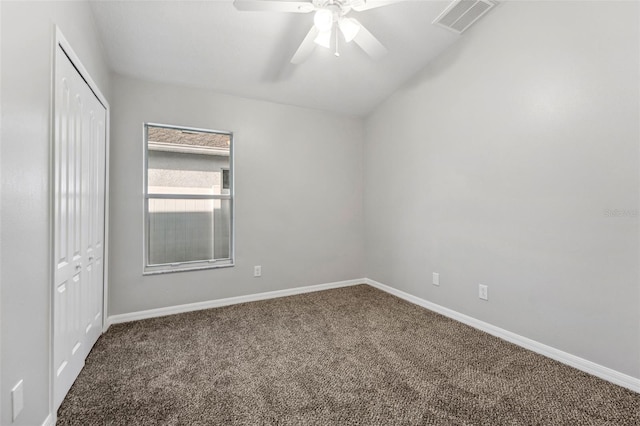 carpeted spare room featuring a ceiling fan, visible vents, and baseboards