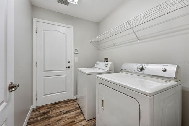 laundry area featuring baseboards, laundry area, washer and clothes dryer, and dark wood-style flooring