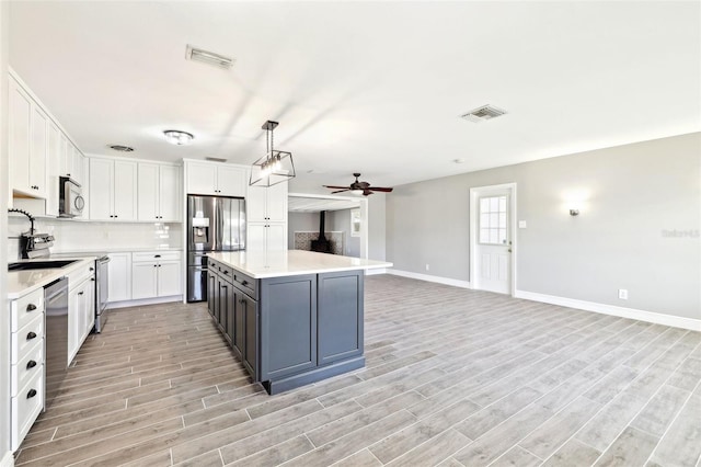 kitchen with visible vents, appliances with stainless steel finishes, white cabinets, and light countertops