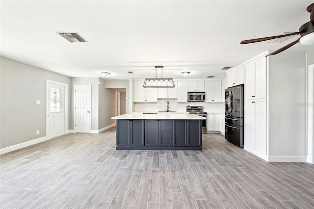 kitchen featuring white cabinetry, visible vents, stainless steel appliances, and a sink