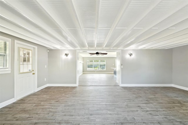 empty room with wood finished floors, a ceiling fan, and baseboards