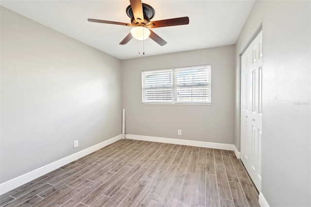 interior space featuring ceiling fan, wood finished floors, and baseboards