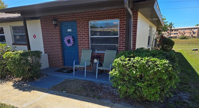 doorway to property featuring brick siding