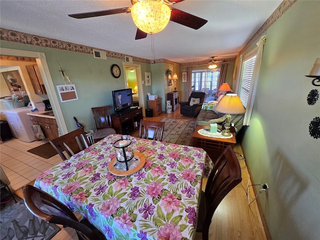 dining room featuring washer / dryer, visible vents, and a textured ceiling