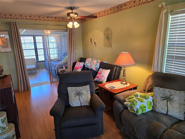 living area with ceiling fan and wood finished floors