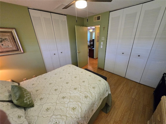 bedroom with visible vents, ceiling fan, and wood finished floors