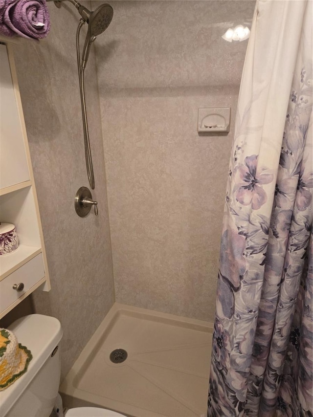 bathroom featuring toilet and a shower with shower curtain