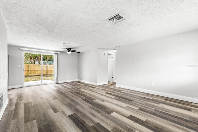 empty room featuring visible vents, baseboards, and wood finished floors