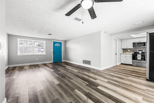 unfurnished living room featuring light wood-style floors, visible vents, and baseboards