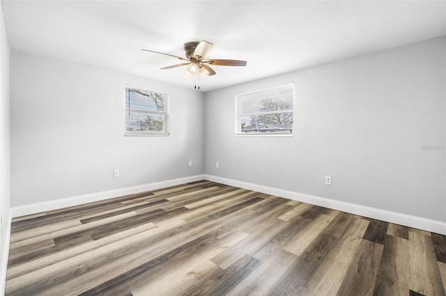 empty room with ceiling fan, baseboards, and wood finished floors