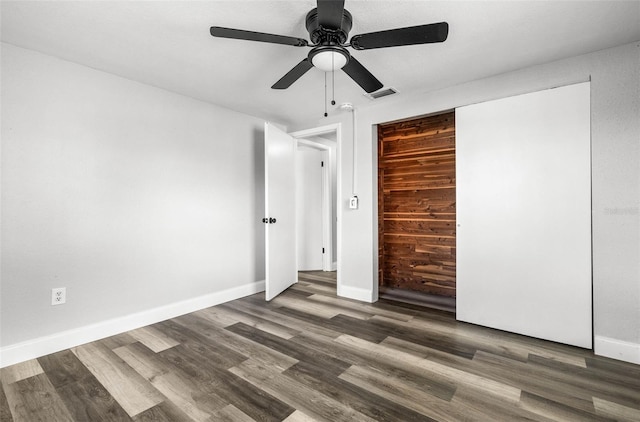 unfurnished bedroom featuring a ceiling fan, baseboards, visible vents, and wood finished floors