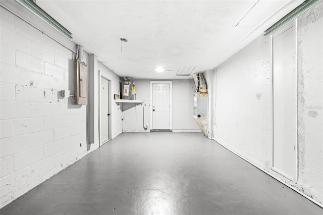 garage featuring water heater, electric panel, and concrete block wall