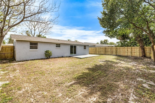 back of property featuring a lawn, a patio area, a fenced backyard, and stucco siding