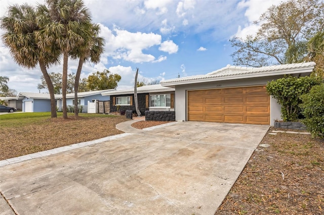 ranch-style home featuring driveway, an attached garage, and stucco siding