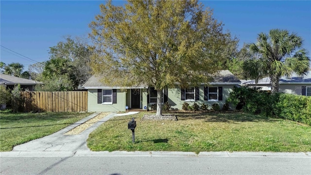 view of front of house with fence, driveway, and a front lawn