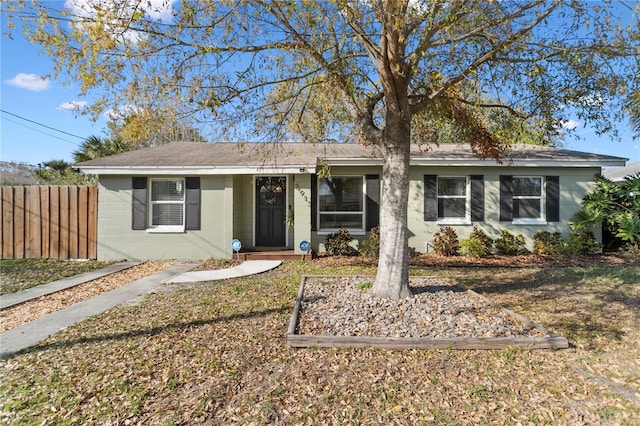 view of front of house with concrete block siding and fence