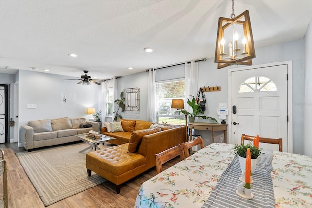 dining area featuring ceiling fan with notable chandelier, recessed lighting, a textured ceiling, and wood finished floors