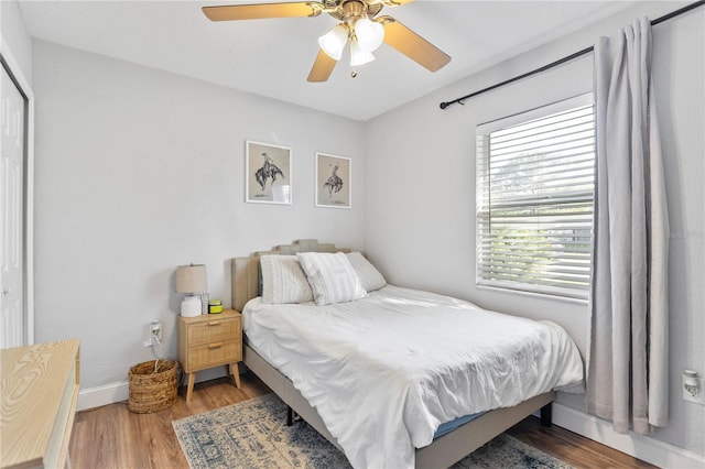 bedroom featuring ceiling fan, baseboards, and wood finished floors