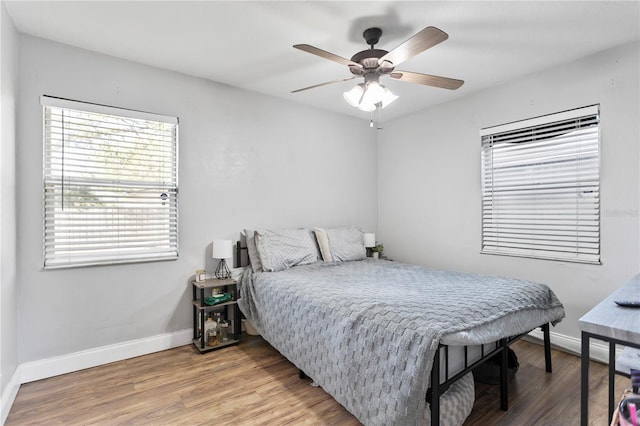 bedroom featuring ceiling fan, baseboards, and wood finished floors