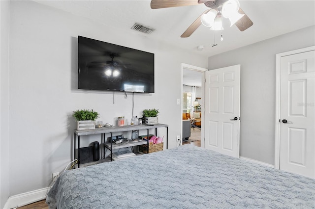 bedroom featuring a ceiling fan, visible vents, and baseboards