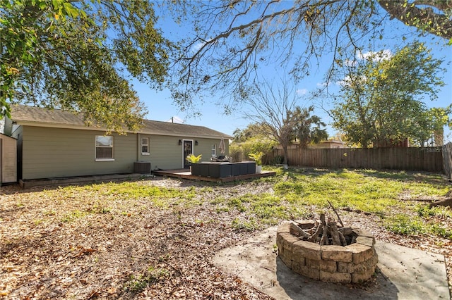 rear view of house featuring an outdoor fire pit, a fenced backyard, and a deck