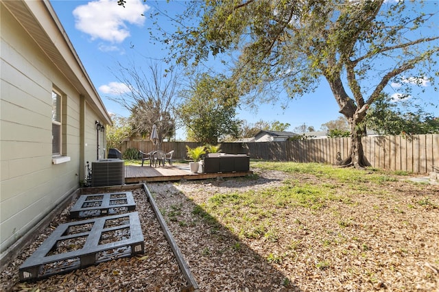 view of yard featuring a fenced backyard, central AC unit, and a deck