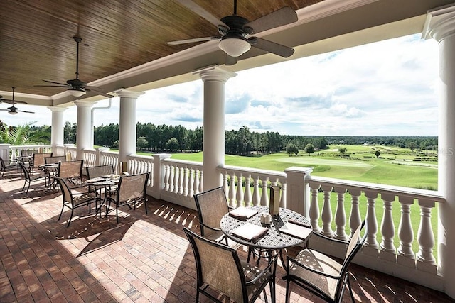 view of patio / terrace with ceiling fan, view of golf course, and outdoor dining area