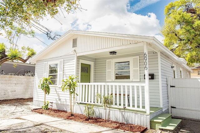 view of front of home featuring covered porch and fence