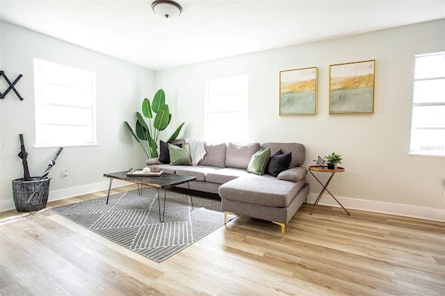 living area with baseboards and wood finished floors