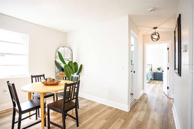 dining area featuring baseboards and light wood-style floors