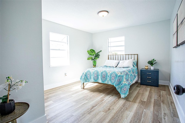 bedroom featuring light wood-style flooring and baseboards