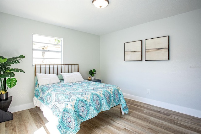 bedroom with baseboards and wood finished floors